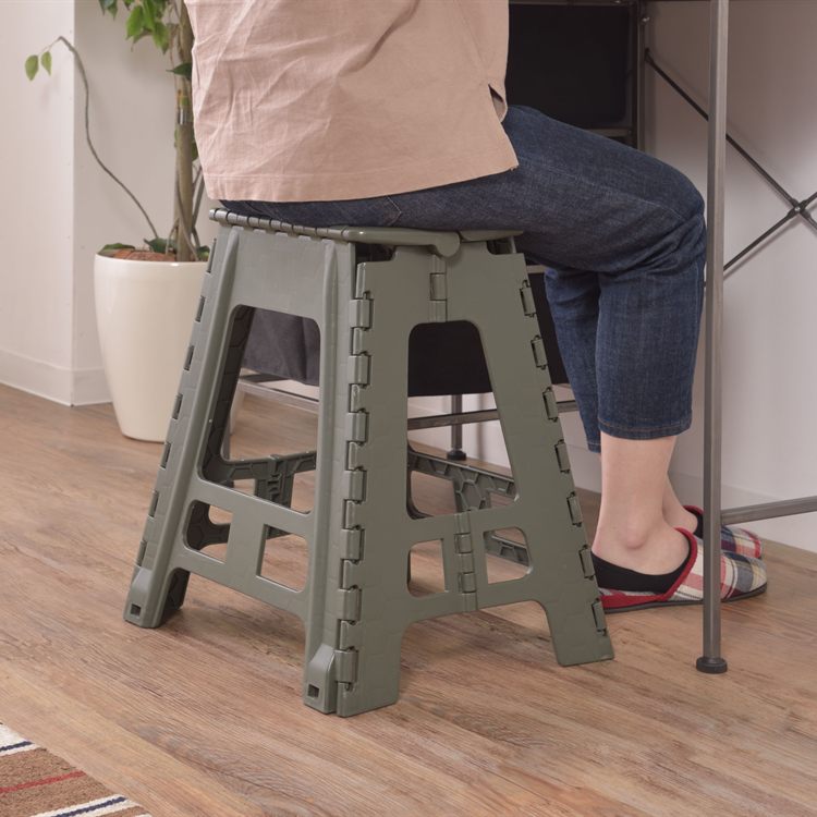 デスクで作業スツールに座って作業をする女性のイメージ写真