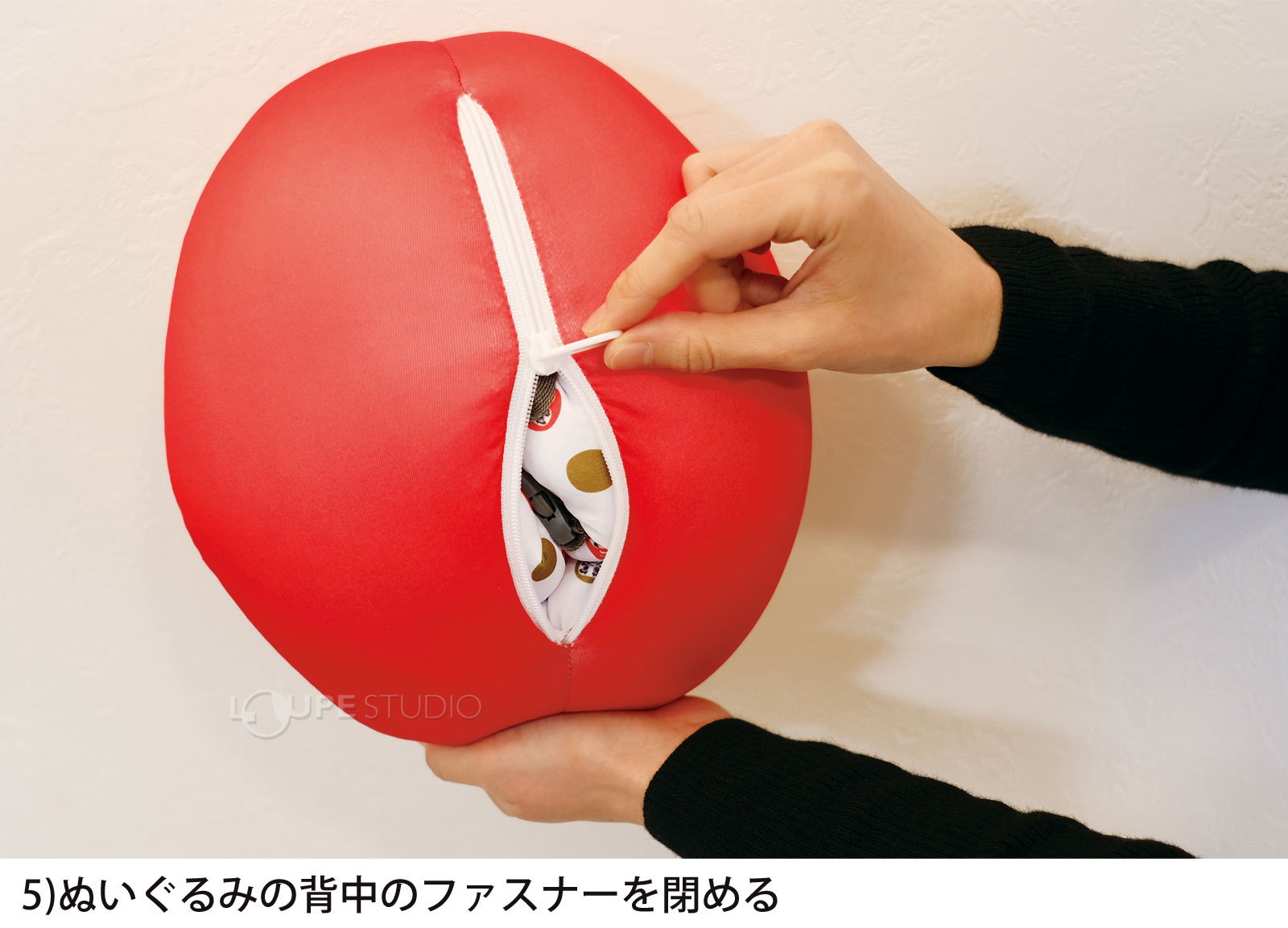ぬいぐるみの背中のファスナーを閉める 