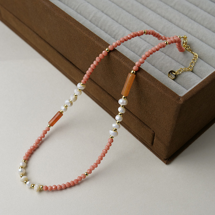 コーラルウィスパー。淡水パールとピンクオパールのやわらかな色合いは肌なじみがよく、優しい印象に。