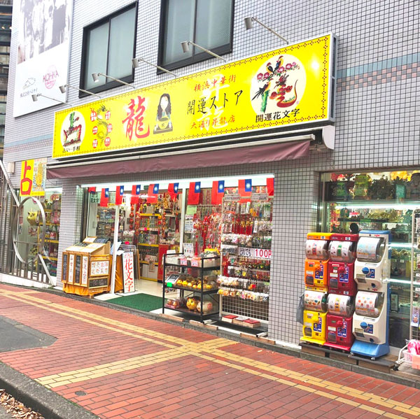 三角の形の建物が印象的な、当店昇龍店。入口には台湾の国旗が並び、花文字やガチャポンの台も見えます