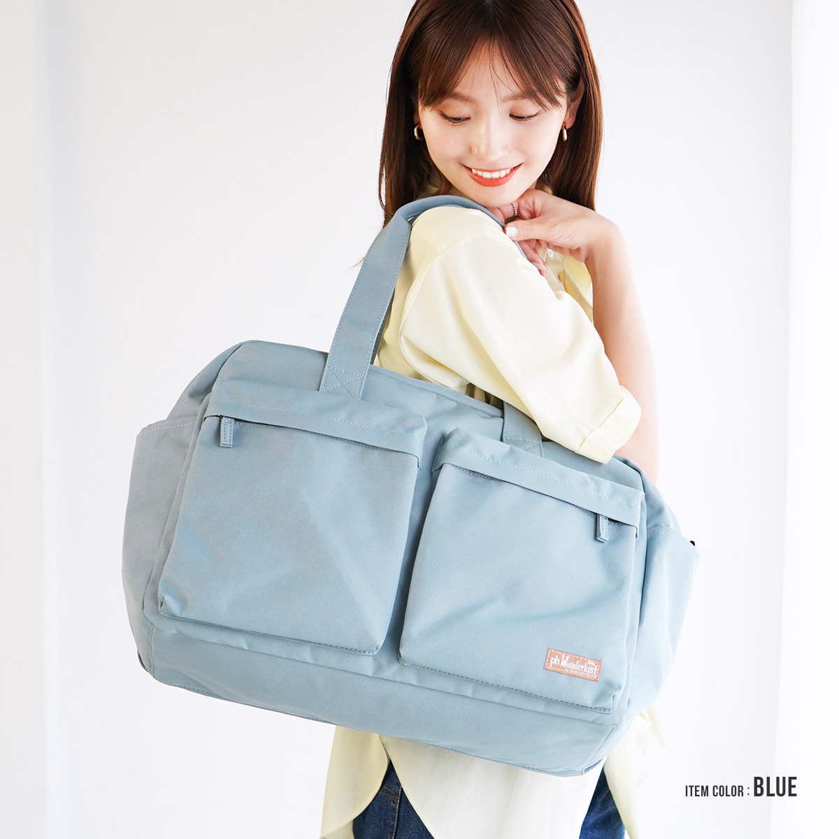 ブルーのボストンバッグを肩にかけた女性モデル|A3対応の大容量サイズ