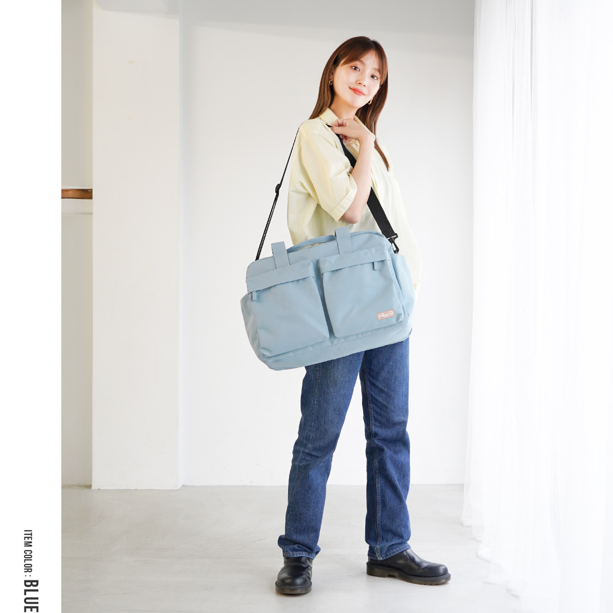 ブルーのボストンバッグを斜め掛けした全身イメージ|2WAY仕様で肩掛けも可能