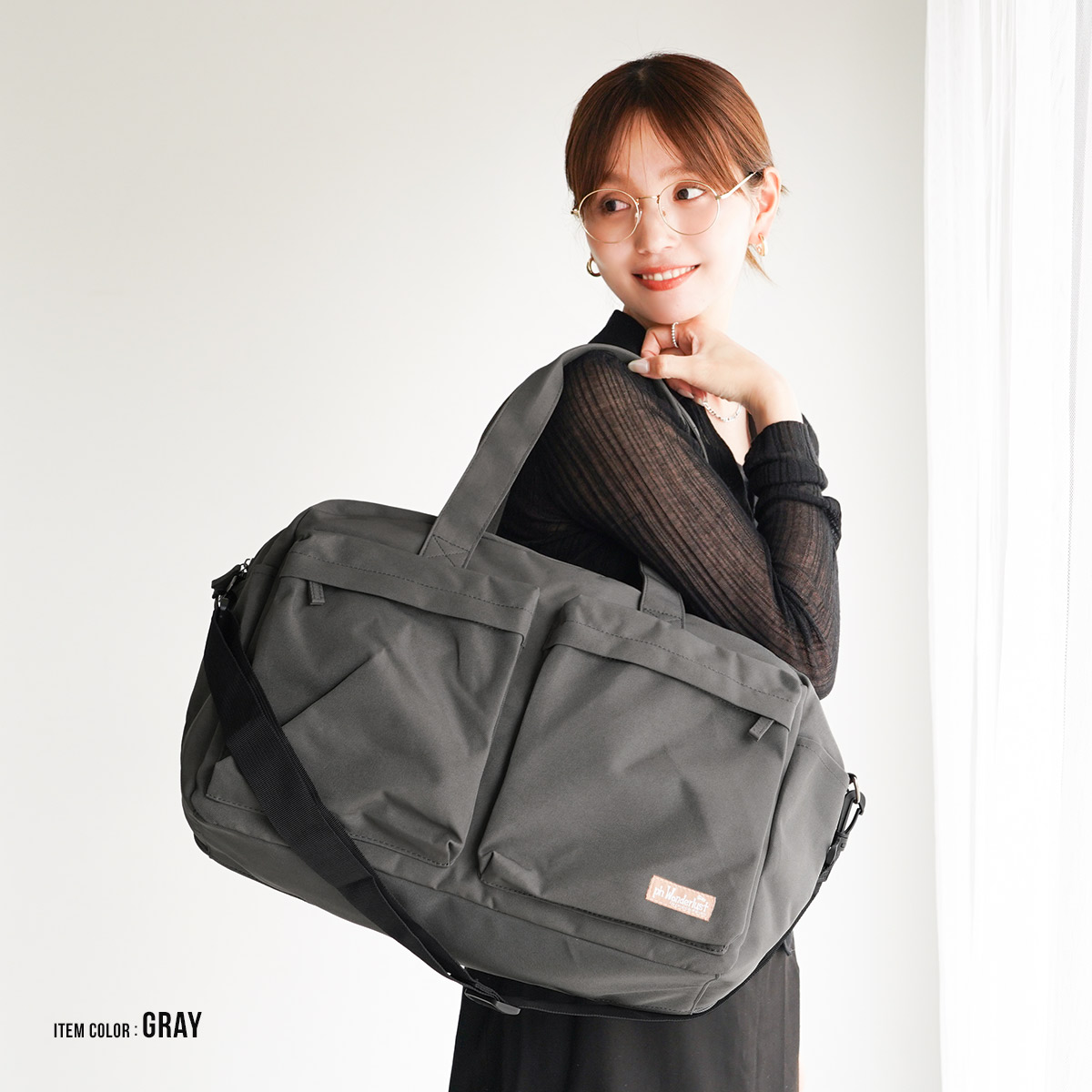 グレーのボストンバッグを肩掛けした女性モデル|落ち着いたカラーで普段使いにも