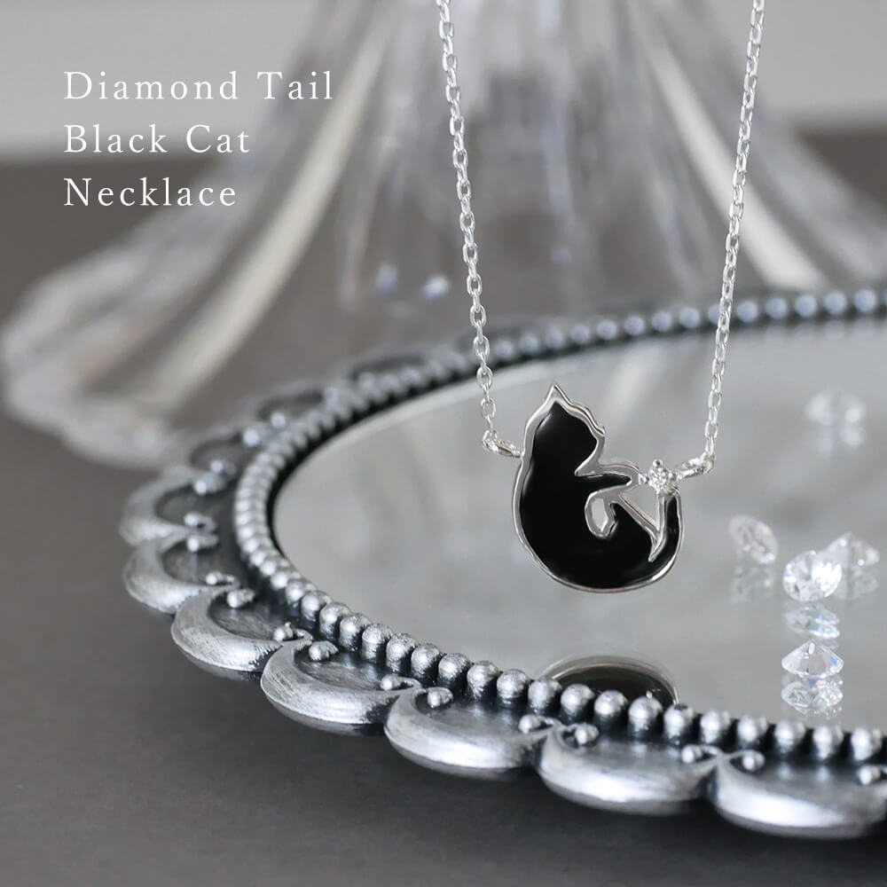 しっぽの先のダイヤモンドにじゃれて遊ぶキュートな黒ネコ 