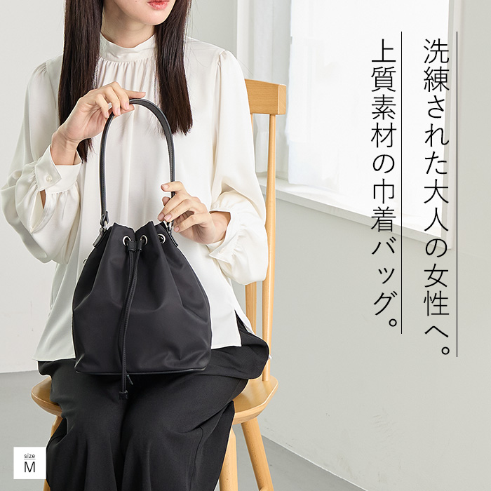 本革ハンドルを使用したナイロン巾着バッグ。大人のきれいめコーデにも合わせやすいデザイン。