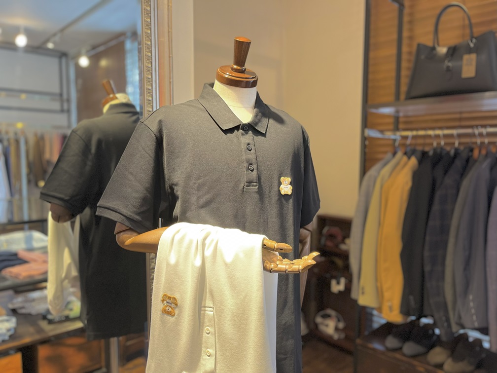 「ベア刺繍がアクセントのモスキーノポロシャツを着用したスタイリング展示」