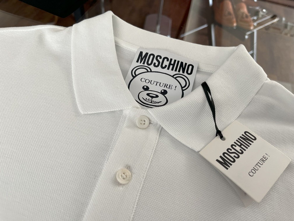 「モスキーノのロゴ入りタグが付いた白ポロシャツの襟部分」