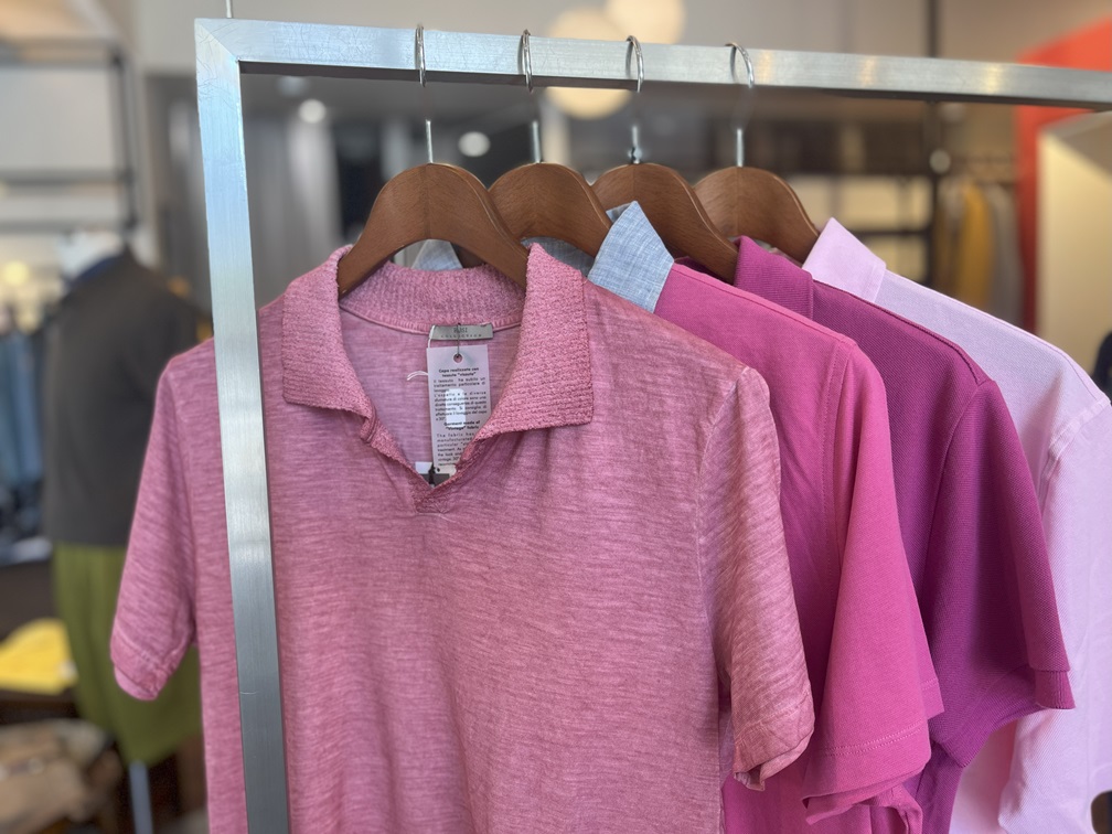ピンク系ポロシャツが並ぶ店頭ラックのディスプレイ