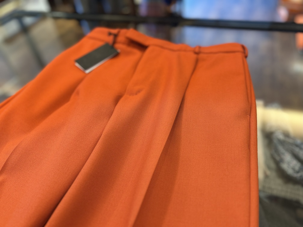 ヴァージンウール生地の艶を映したPT TORINOオレンジパンツの素材アップ。