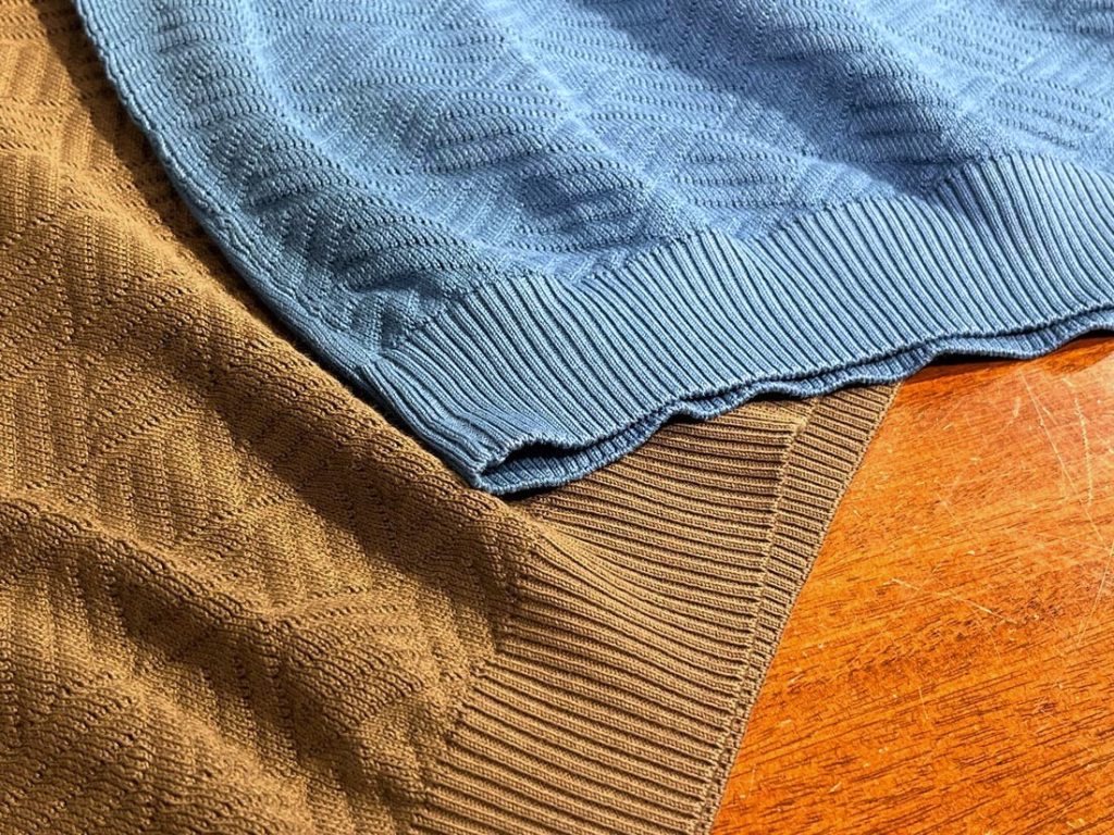 幾何学パターンの凹凸とリブの締まりが分かるディテール写真。さらっとした肌離れの良い編地で夏も快適に着られることを伝える接写。